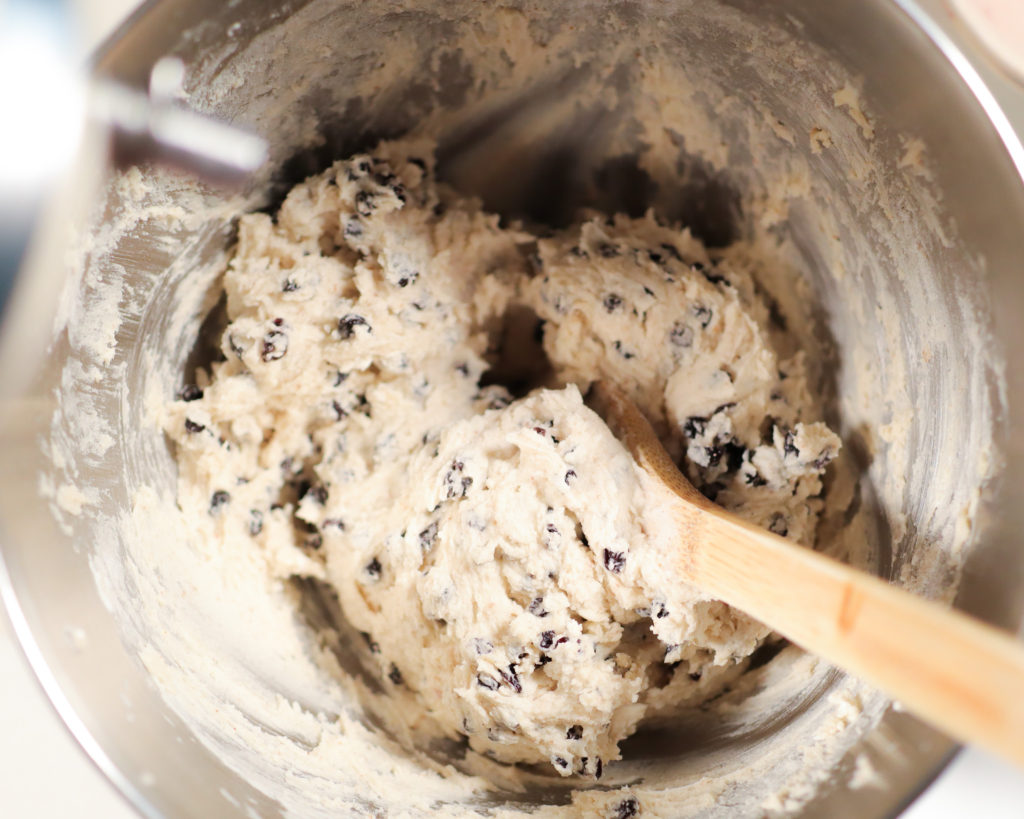 a bowl with cookie dough and wooden spoon inside