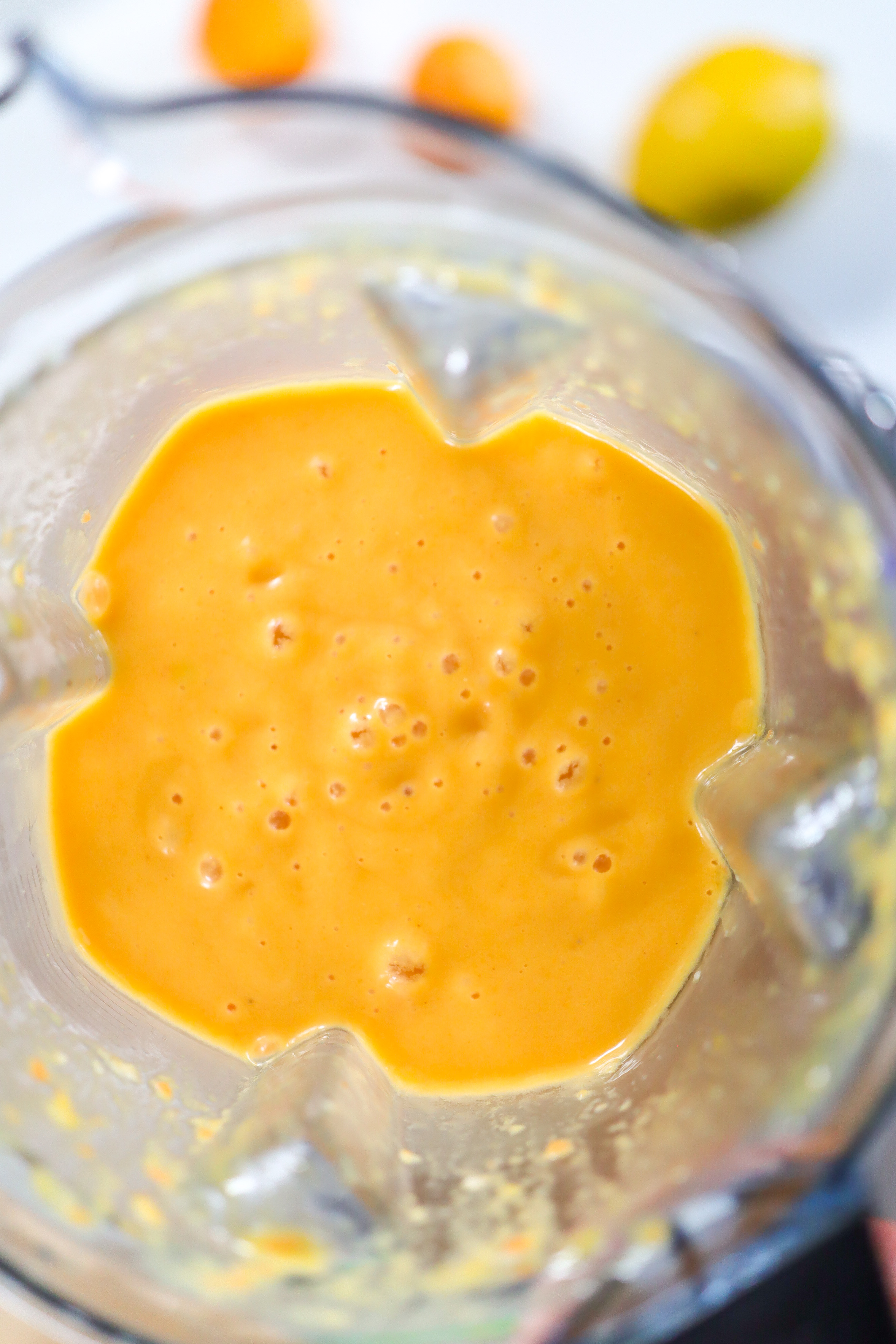 blender with orange-coloured smoothie inside