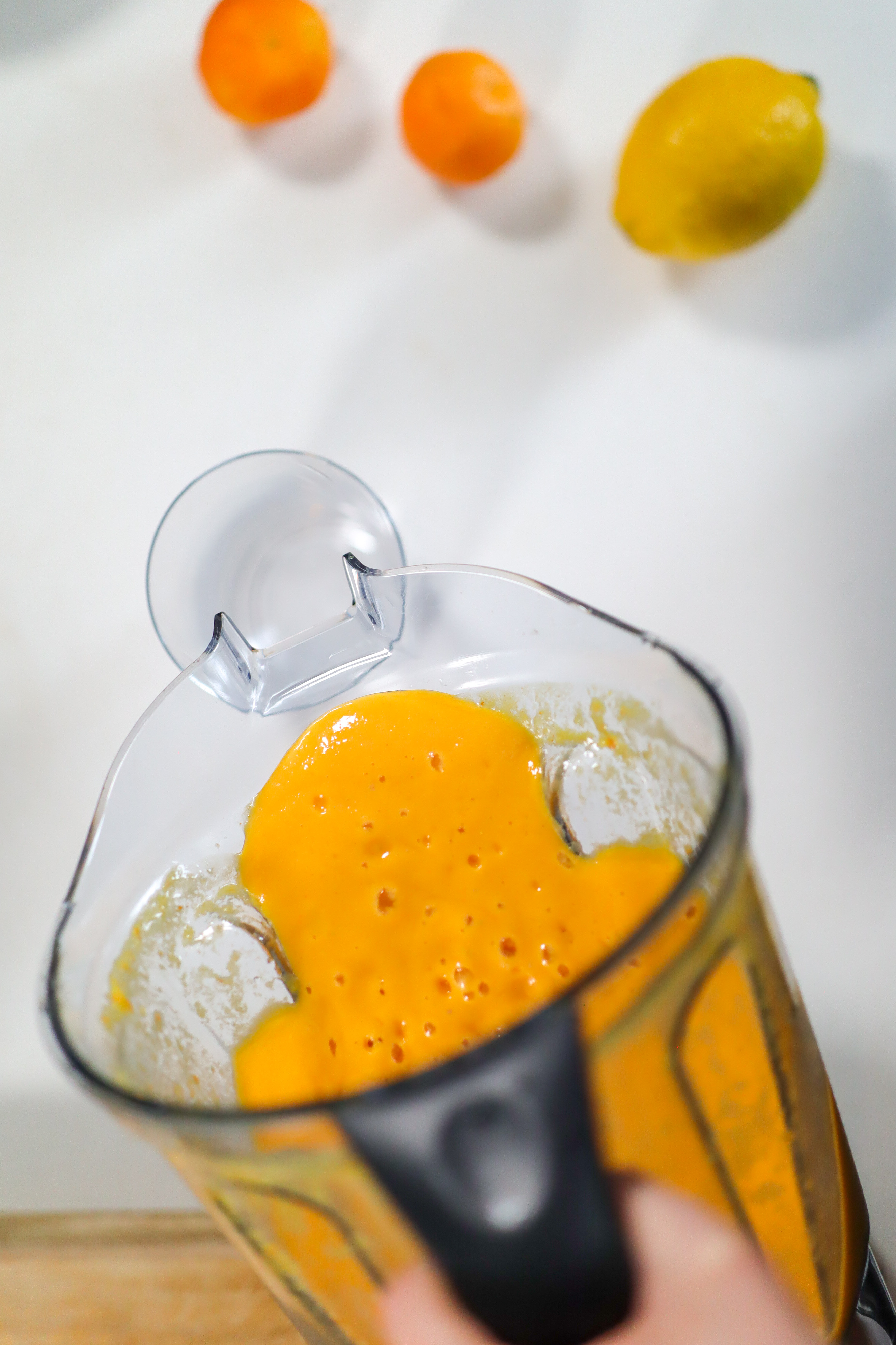 orange drink being poured out of a blender