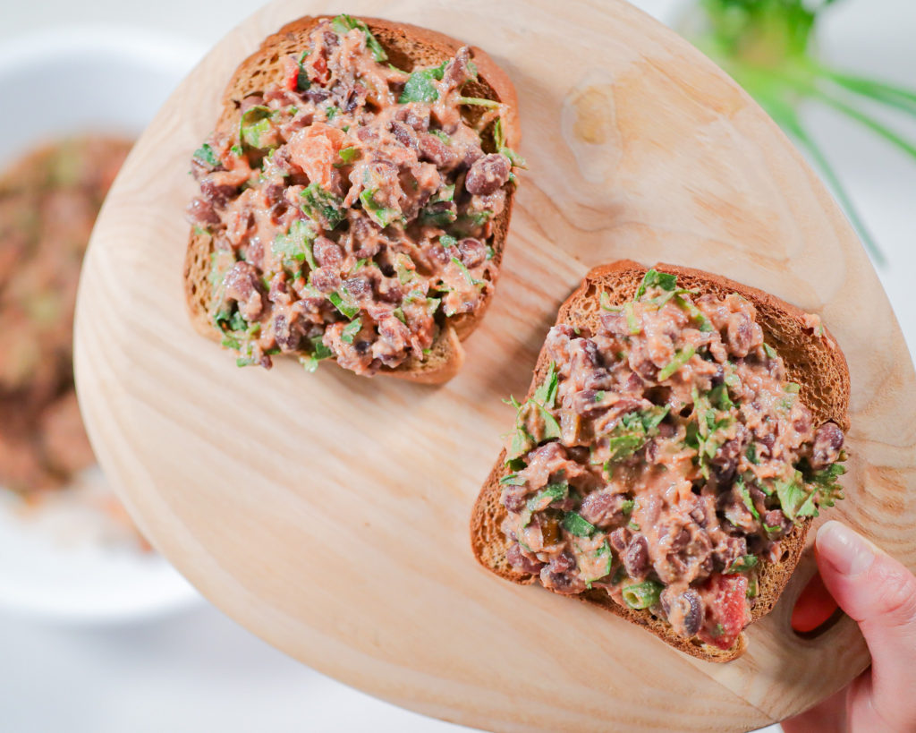 two slices of bread with mashed bean salad on top