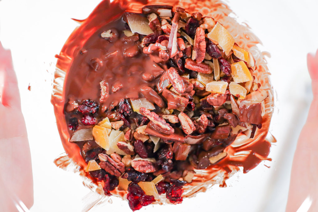 Bowl of melted chocolate and dried fruit and nuts.