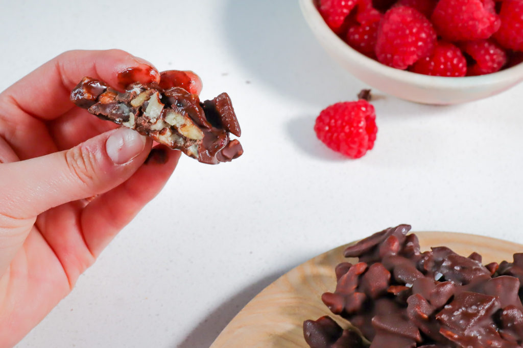 Hand holding a chocolate nut cluster.