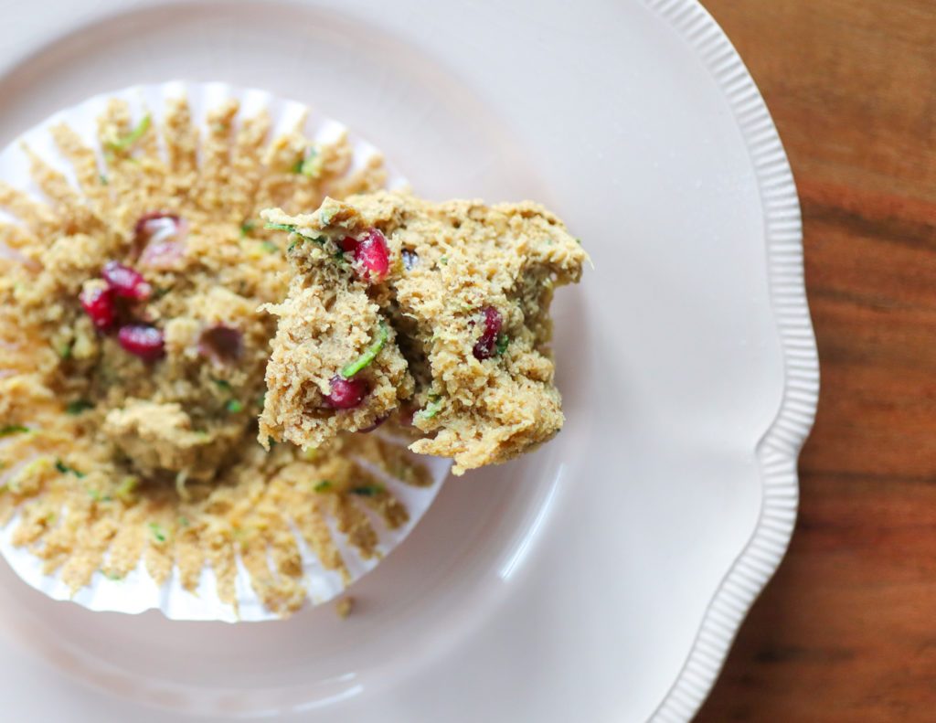 half-eaten muffin on a plate with muffin wrapper beneath it