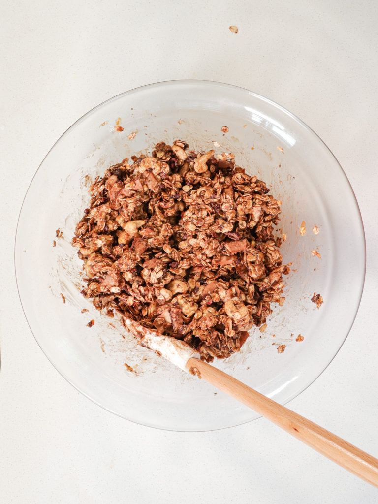 Bowl of granola with a mixing spoon.