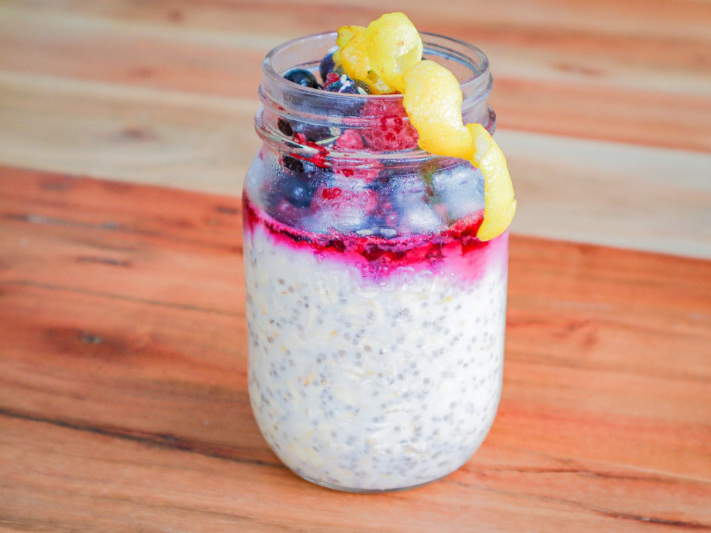 jar of overnight oats, berries and lemon zest on top